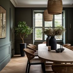 a dining room with wicker chairs and a round table