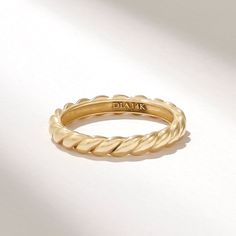 a close up of a gold ring on a white surface with the word diaak written in it