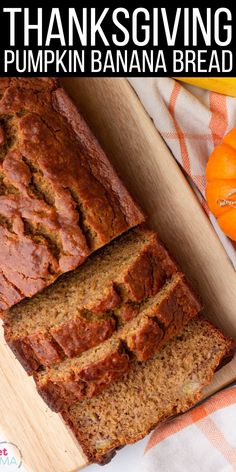 a loaf of pumpkin banana bread sitting on top of a cutting board next to an orange pumpkin