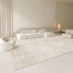 a living room with white furniture and large rugs on the floor in front of a window