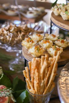 a table topped with lots of food on top of wooden serving trays next to each other