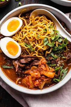 a bowl filled with noodles, meat and eggs