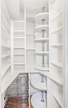 an empty pantry with white shelves and wooden flooring is pictured in this image from the inside