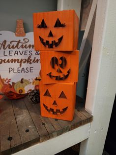 three carved pumpkins are stacked on top of each other