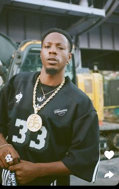 a man wearing a black jersey and gold chain