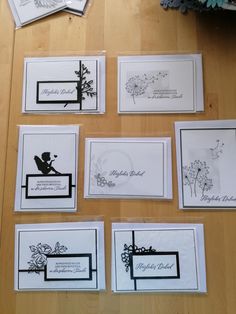 some cards are laying on a table with flowers in the middle and black and white designs