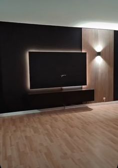 a living room with hard wood flooring and a flat screen tv mounted on the wall