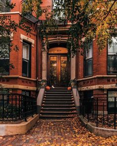 an old brick building with stairs leading up to the front door and steps down to the second floor