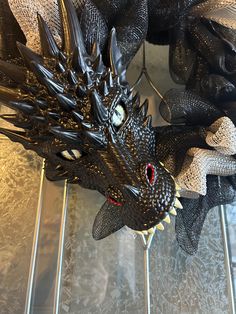 a black dragon statue sitting on top of a metal shelf