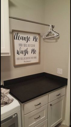 a kitchen with white cabinets and black counter tops in front of a sign that reads clean me and i will be clean wash me