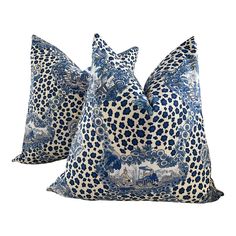 two blue and white pillows sitting on top of each other