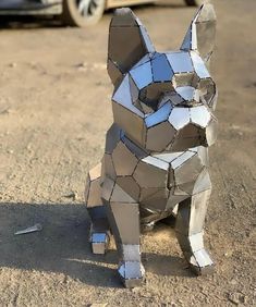 a sculpture of a dog made out of pieces of paper on the ground next to a car