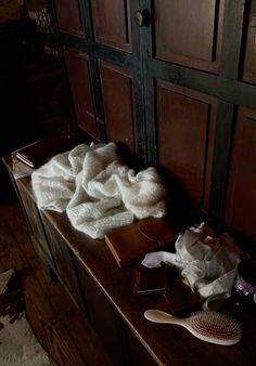 a pile of hair sitting on top of a wooden table next to a brush and comb