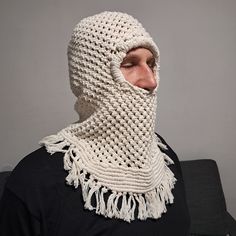 a man wearing a crocheted white scarf with a hood on his head and neck