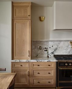 a kitchen with marble counter tops and wooden cabinets, along with a stove top oven