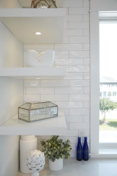 the shelves in the kitchen are filled with vases and other decorative items on them