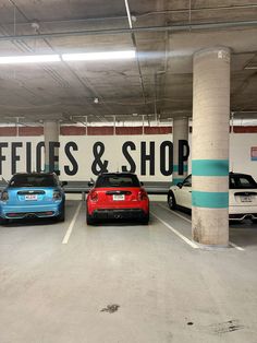 three cars parked in a parking garage with a sign that says office & shop on the wall