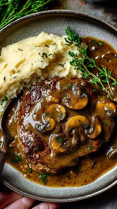 a plate with mashed potatoes, mushrooms and gravy