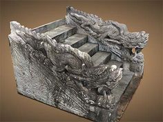 an intricately carved stone box with two dragon heads on it