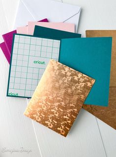 several different colored envelopes with gold foil on them