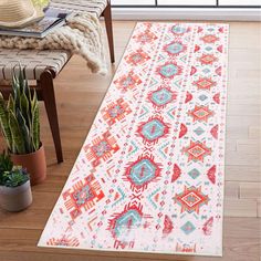 an area rug in the living room with potted cacti on the floor