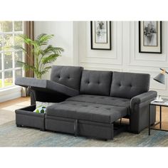 a living room scene with focus on the sectional sofa and footstool that is open