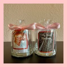 two glass jars with pink ribbon and pictures on them