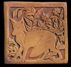 a decorative tile with a fox and flowers on it's side, in the shape of a rectangle