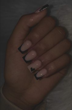 a woman's hand with black and white manicures on her nails, in the dark