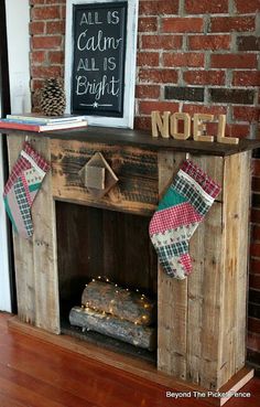 a fireplace mantel with stockings hanging from it's sides and a chalkboard sign on top