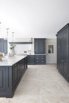 a large kitchen with blue cabinets and marble counter tops