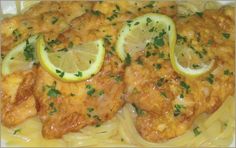 chicken with sauce and lemon slices served on pasta