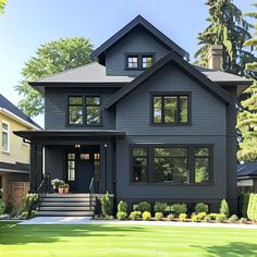 a large gray house with lots of windows on the front and side of it's roof