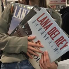 a woman holding several books in her hands