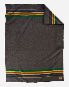 a gray blanket with yellow, green and blue stripes on the bottom is folded up