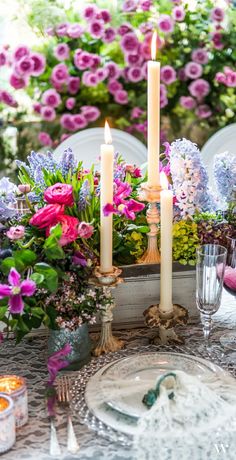 the table is set with candles, plates and silverware for a festive dinner