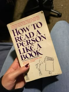 a person is holding up a book in their hand, with the title how to read a person like a book