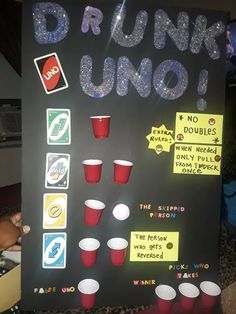 a sign that says drunk uno with cups and sodas on the side, in front of it