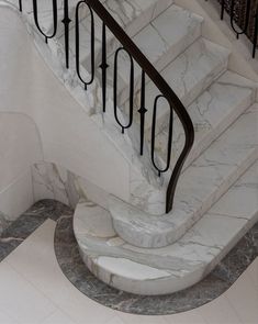 a marble staircase with wrought iron handrails