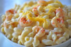 a white bowl filled with macaroni and cheese covered in shrimp