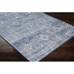 a blue and white area rug on top of a wooden floor with dark wood floors