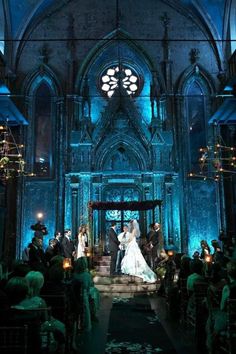 a bride and groom are standing in front of the alter at their wedding ceremony with blue lighting