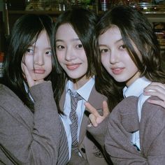 three young women posing for the camera with their arms around each other