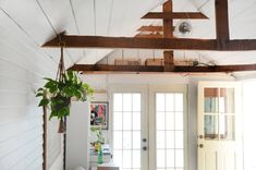 a room with a cross hanging from the ceiling and a potted plant in front of it