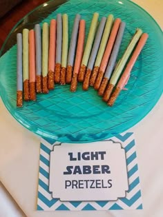 there is a blue plate with candles on it and a sign that says light saber pretzels