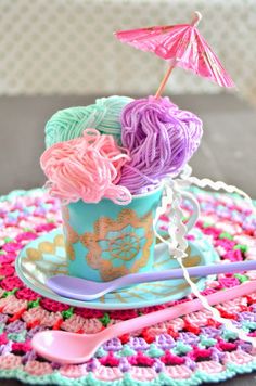 crocheted doily and cup with yarn in it sitting on top of a table