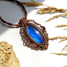 Labradorite Wire Wrapped Pendant, handcrafted with care and passion using high-quality copper wire. This unique piece features a dazzling blue Labradorite, known for its enchanting flashes of color. Why You'll Love It: Handmade with Love: Each pendant is meticulously crafted using the wire wrapping technique, making every piece one-of-a-kind. Mesmerizing Blue Labradorite: The stone's natural iridescence catches the light beautifully, offering a captivating sparkle. Adjustable Leather Cord: Comes with a stylish, adjustable leather cord for the perfect fit and comfortable wear. Perfect Size: The pendant measures 4x6 cm, making it a great statement piece for any outfit. Ready to Ship: This necklace is ready to be sent your way. Choose express shipping for faster delivery! A Touch of Magic: Cr Blue Gemstone Necklace, Wire Wrapping Techniques, Copper Wire Jewelry, Talisman Necklace, Labradorite Necklaces, Copper Pendant, Copper Necklace, Blue Labradorite, Spiritual Jewelry