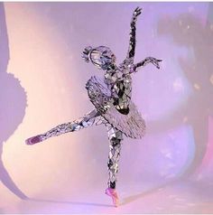 a woman is dancing with her arms spread out in the air and legs bent forward