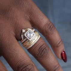 a woman's hand with two rings on her fingers and one ring in the shape of a heart