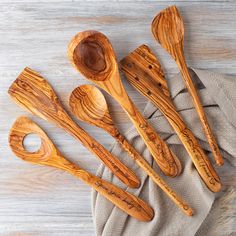 wooden spoons and spatulas sitting on top of a cloth